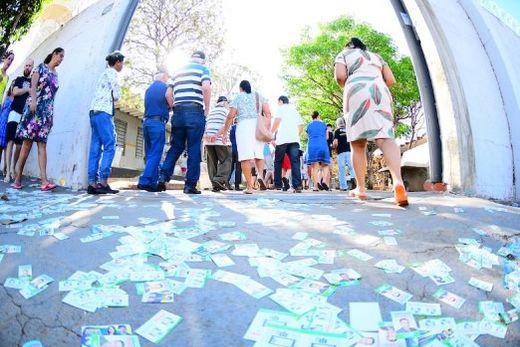 No portão da Escola 'Chlorita Martins'. Pessoas passam por cima de milhares de 'santinhos'