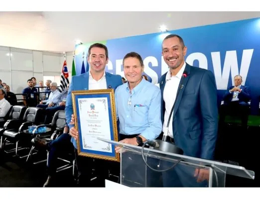 Reconhecimento na Agrishow. João Marchesan, com o título de cidadania em mãos, entre Ricardo Silva (prefeito de Ribeirão Preto) e Matheus Moreno (autor da propositura)