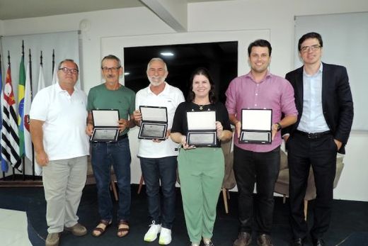 Os homenageados. Representantes das lojas aniversariantes (com as placas nas mãos) receberam os parabéns de Toninho Giannini e Guilherme Dietze
