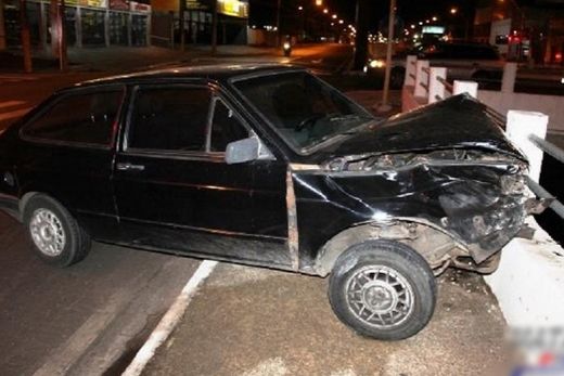 Carro bate em caminhão e quase cai no rio