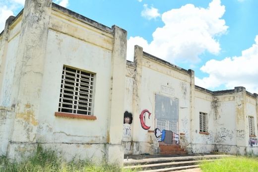 A antiga Estação Ferroviária. Mato alto ao redor reforça o estado de abandono do prédio