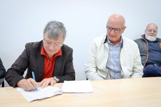 No papel. O prefeito Cido Ferrari assina o convênio, observado por Manoel Braga (Apae)