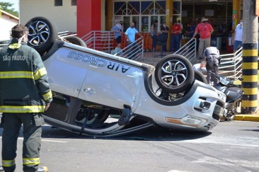 Mulher fica ferida após carro capotar na frente de supermercado — foto 2 de 3